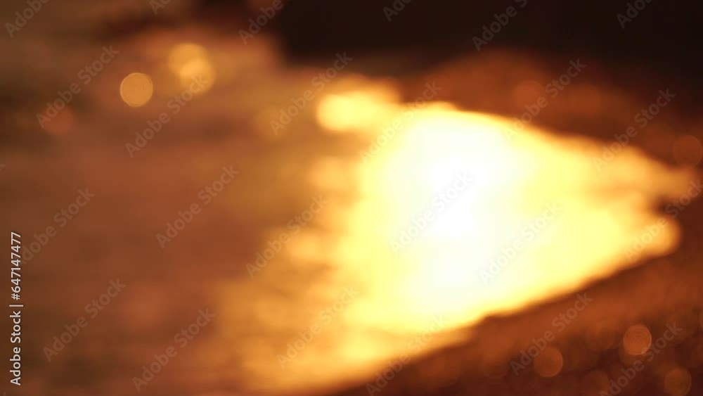Blurred golden sea at sunset. The sun reflects and sparkles on the waves with bokeh, illuminating the golden sea. Holiday recreation concept. Abstract nautical summer ocean sunset nature background. Blurred golden sea at sunset. The sun reflects and sparkles on the waves with bokeh, illuminating the golden sea. Holiday recreation concept. Abstract nautical summer ocean sunset nature background.
