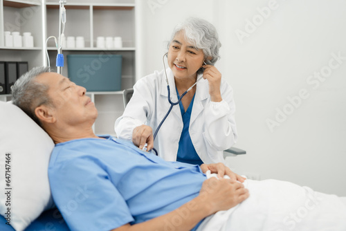Doctor uses a stethoscope listen to the heart rate for the patient to lie in the patient’s bed. Medical concept. Health check.