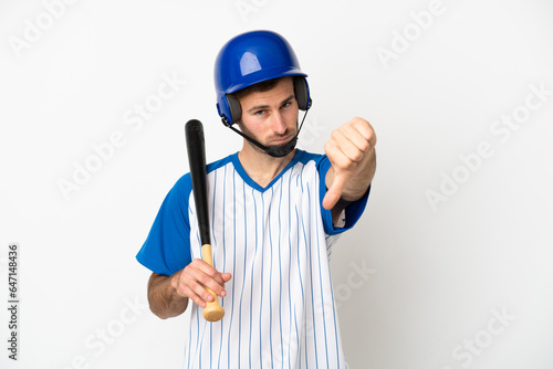 Young caucasian man playing baseball isolated on white background showing thumb down with negative expression