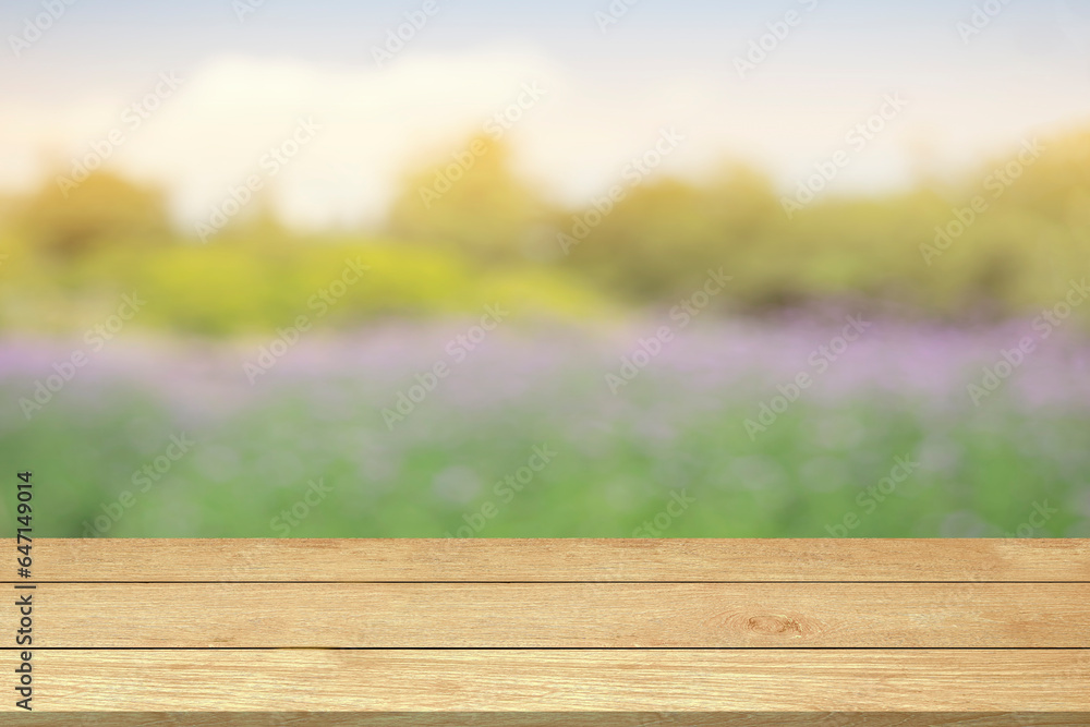 Empty wooden table top or counter blur flowers garden nature background in green trees spring park sunlight sky for template mock up and display montages product. Wood table plank background Empty wooden table top or counter blur flowers garden nature background in green trees spring park sunlight sky for template mock up and display montages product. Wood table plank background