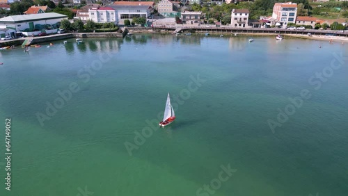 A Boat Sailing In the Middle Of The Sea During Daytime Near Aldan Port In Spain. aerial, pan shot photo