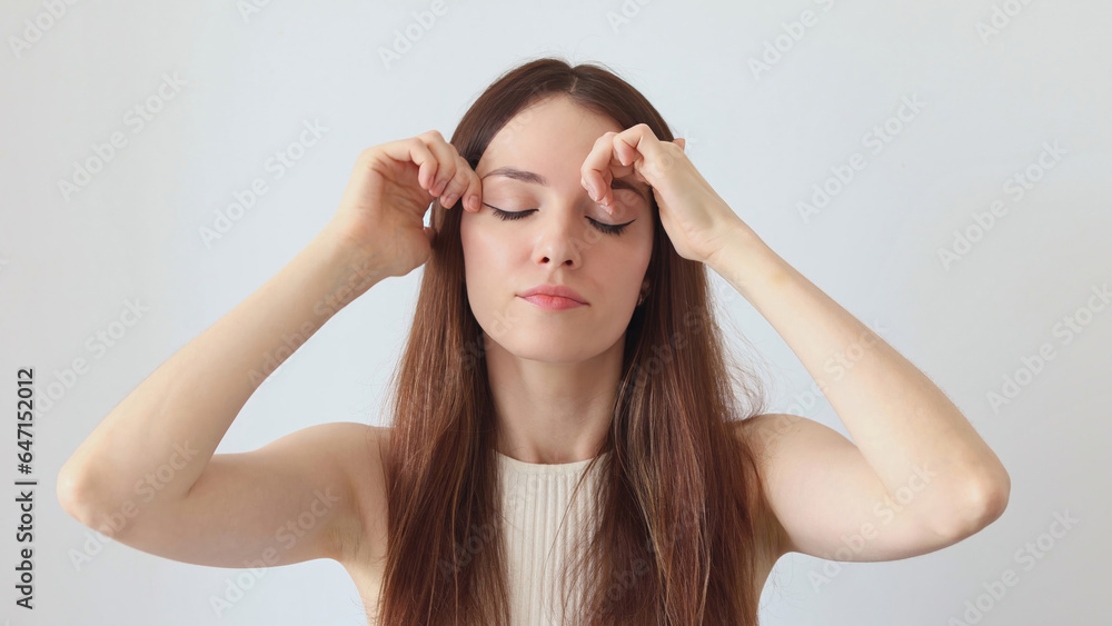 Fototapeta premium A beautiful woman gives a facial massage with her hands