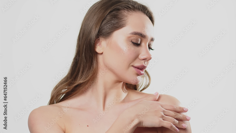 A beautiful woman with clean skin applies moisturizer to her décolleté. Skin care concept, cosmetics and skin care advertising. A beautiful woman with clean skin applies moisturizer to her décolleté. Skin care concept, cosmetics and skin care advertising.