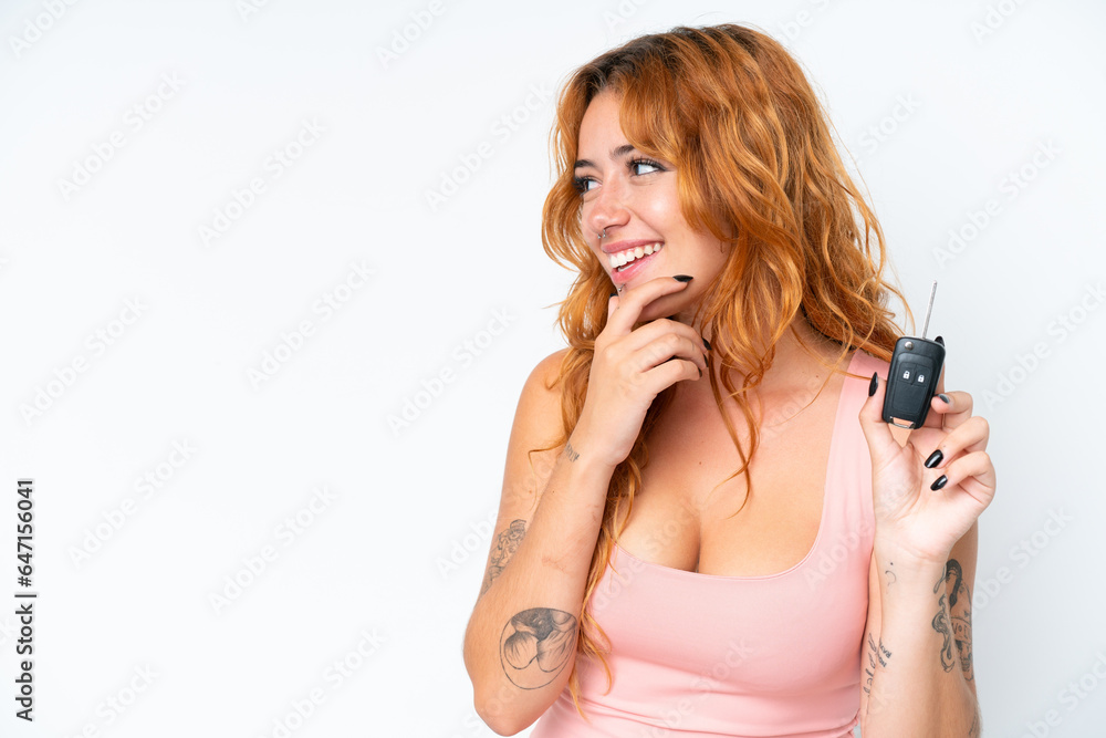 Young caucasian woman holding car keys isolated on white background thinking an idea and looking side Young caucasian woman holding car keys isolated on white background thinking an idea and looking side