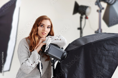 girl photographer with professional equipment getting ready to take photos, Stunning young lady captured in a stylish studio interior, accentuated by advanced lighting and state-of-the-art gear