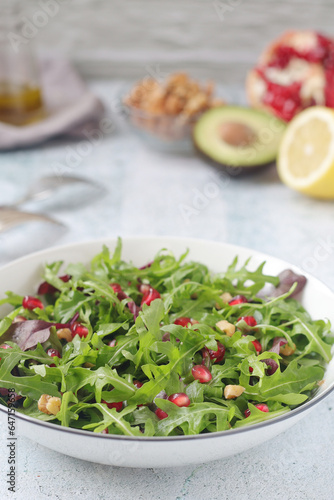 A plate with green rocket salad with pomegranate and avocado 