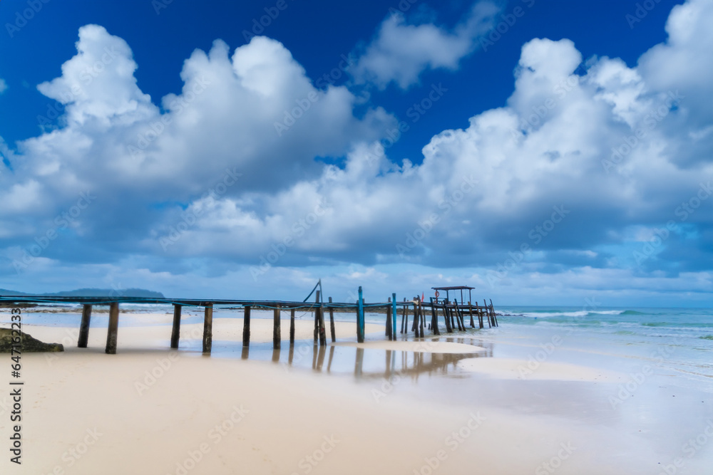 Obraz premium Wooden pier bridge Extending into the Sea, Embracing Thailand's Eastern Island's Rocky Shores as day time.