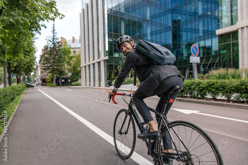 Fototapeta Naklejka Na Ścianę i Meble -  Young man riding a bike in a city center