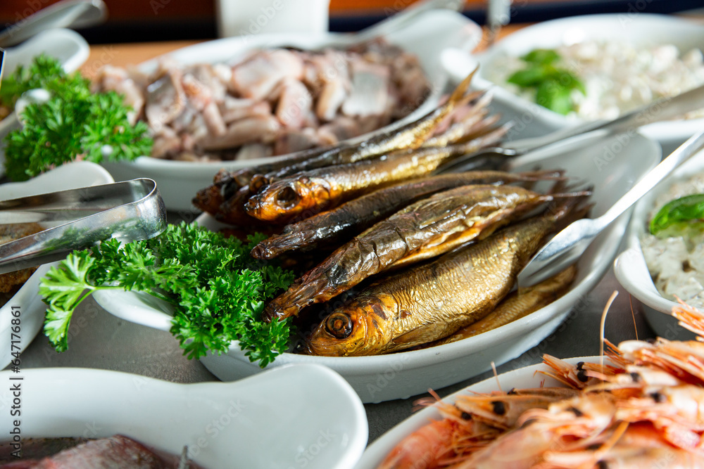 Delicious smoked Baltic herring on a plate. Seafood buffet lunch in a cafe in Finland Delicious smoked Baltic herring on a plate. Seafood buffet lunch in a cafe in Finland