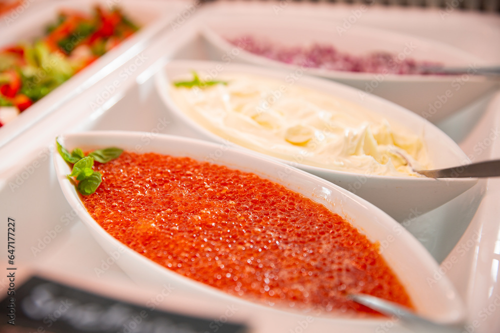 Delicious red caviar on a serving plate on the buffet table in the restorant. Seafood buffet lunch in a cafe in Finland Delicious red caviar on a serving plate on the buffet table in the restorant. Seafood buffet lunch in a cafe in Finland