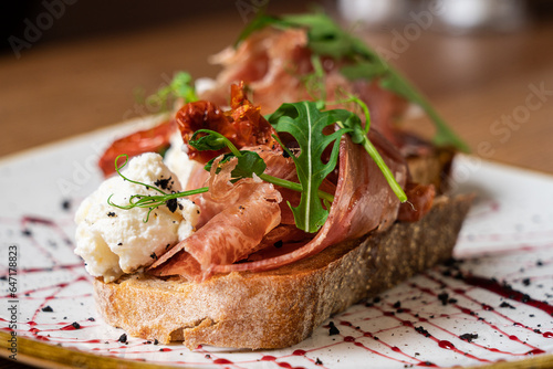 Appetizer with prosciutto, bruschetta. Food, restaurant and event concept. Close-up.