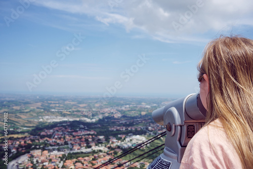 a girl enjoying a city view through a binocular