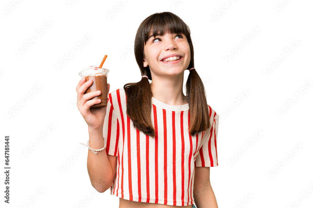 Young man with chocolat milkshake over isolated background looking up while smiling Young man with chocolat milkshake over isolated background looking up while smiling