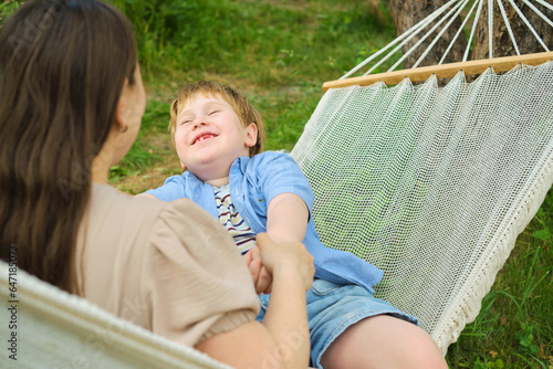 Outdoor Family Bliss: Experience the profound connection between a mother and her 5-year-old as they relax in a hammock, bathed in golden sunlight, engaging in meaningful conversations