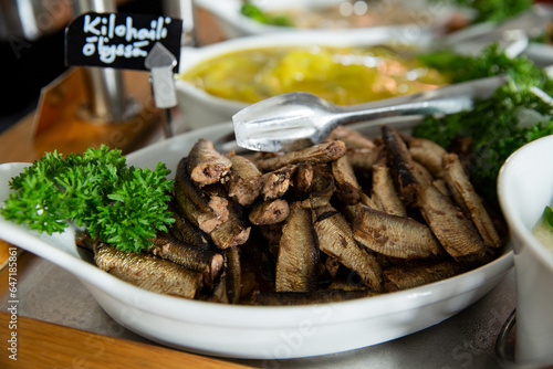 Photos Smoked oil baltic sprats in a serving plate on a buffet table in a restorant