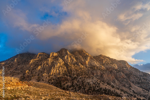 barren mountains with clouds on top © Aytug Bayer