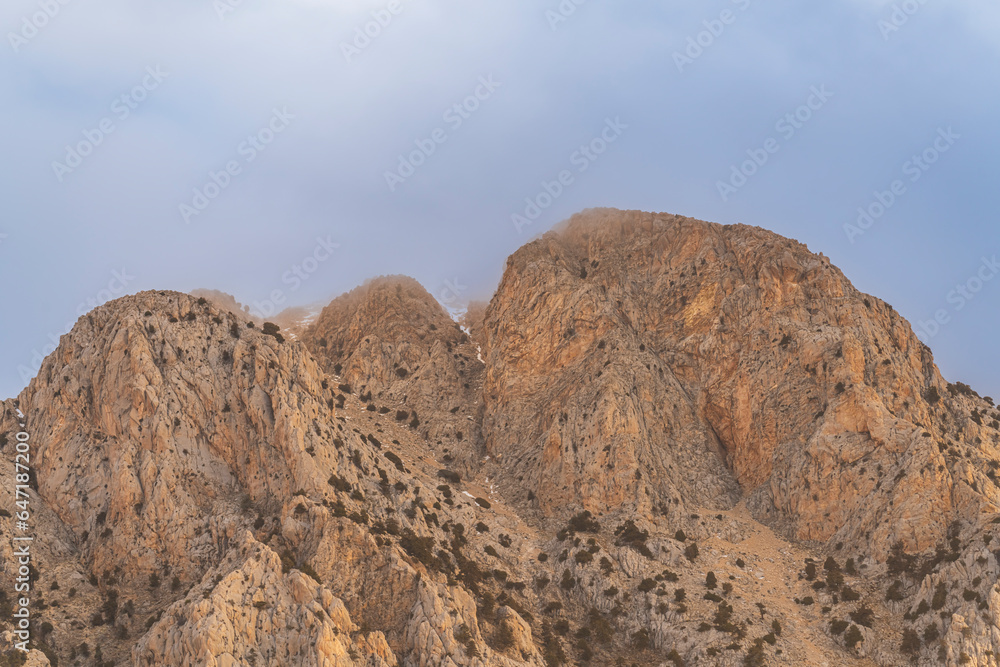 barren mountains with clouds on top