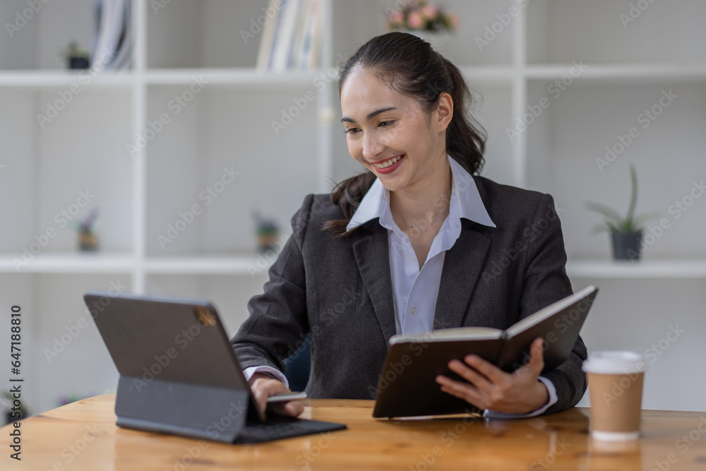 Young asian business woman having a coffee in an work on tablet the office Young asian business woman having a coffee in an work on tablet the office