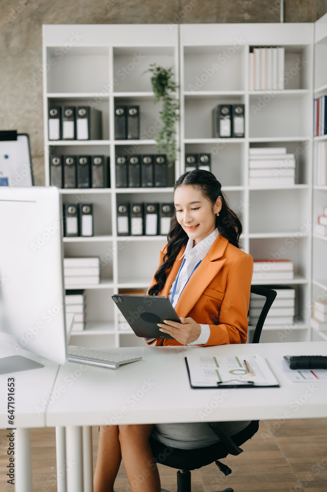 Business woman using tablet and laptop for doing math finance on an office desk, tax, report, accounting, statistics, and analytical research concept in office Business woman using tablet and laptop for doing math finance on an office desk, tax, report, accounting, statistics, and analytical research concept in office