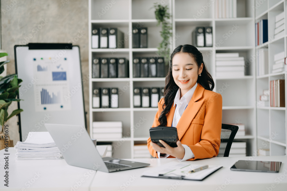 Business woman using tablet and laptop for doing math finance on an office desk, tax, report, accounting, statistics, and analytical research concept in office Business woman using tablet and laptop for doing math finance on an office desk, tax, report, accounting, statistics, and analytical research concept in office