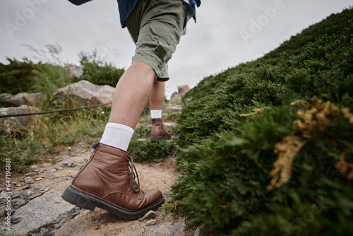 wild nature, cropped view of hiker walking in brown boots with white socks, adventure, traveler