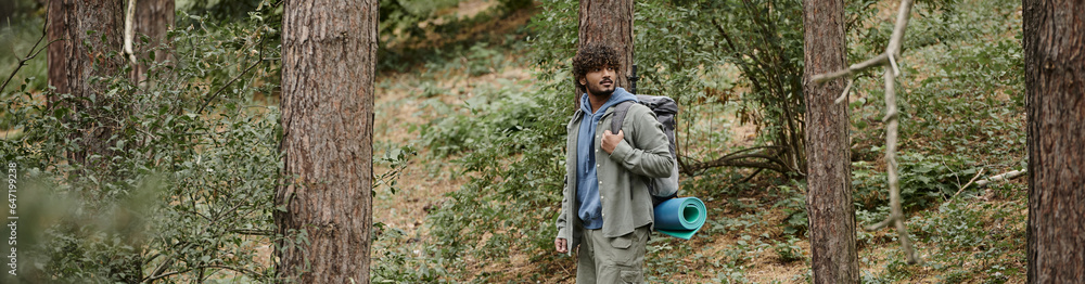 indian backpacker with curly hair walking in forest, natural location, hiker with backpack, banner indian backpacker with curly hair walking in forest, natural location, hiker with backpack, banner