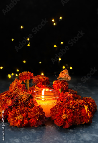 burning candle, butterflies and marigold flowers on abstract dark background. cempasuchil flowers - symbol of Mexico's Day of the Dead. dia de los Muertos holiday concept. esoteric spiritual ritual