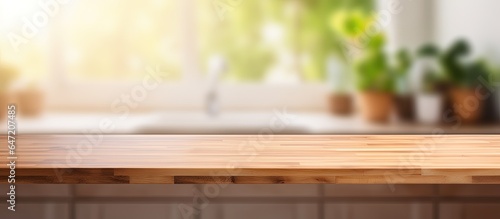 Clean and bright modern kitchen with empty wood table top and blurred bokeh background perfect for product display
