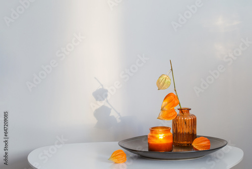 autumnal still life with flowers and candles on white table