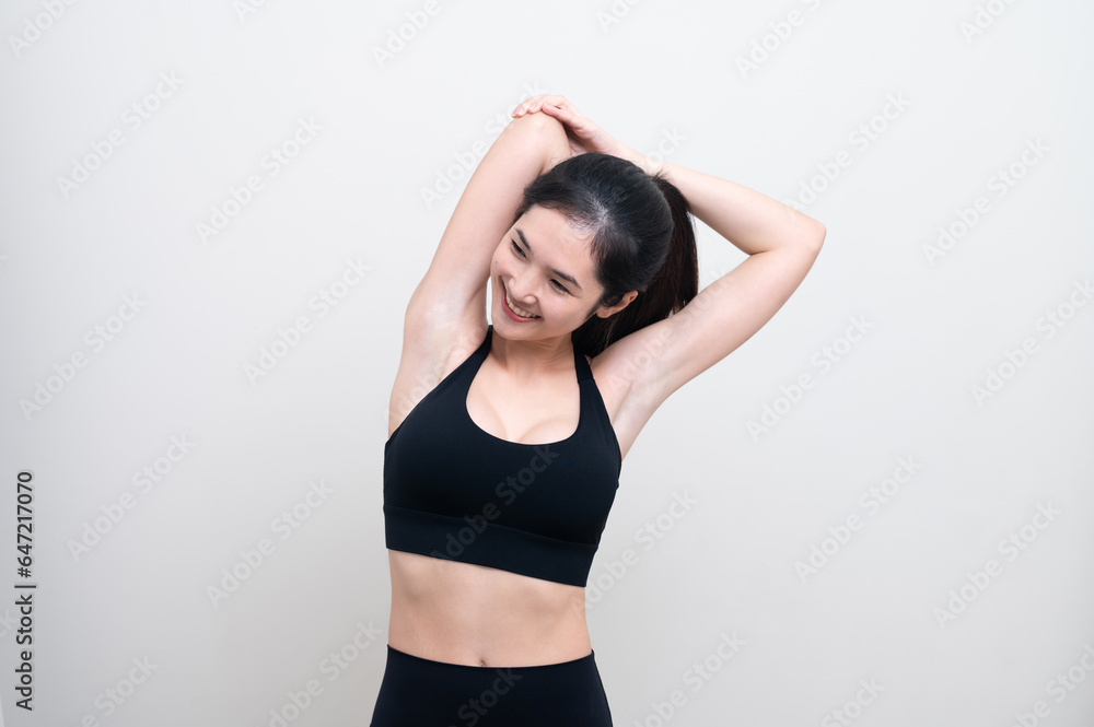 Attractive Asian woman in black workout clothes doing arm stretching on white background. Confident young female athlete body warm up before workout on isolated. Attractive Asian woman in black workout clothes doing arm stretching on white background. Confident young female athlete body warm up before workout on isolated.