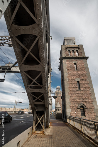 An ancient metal and stone bridge with towers over a wide river.