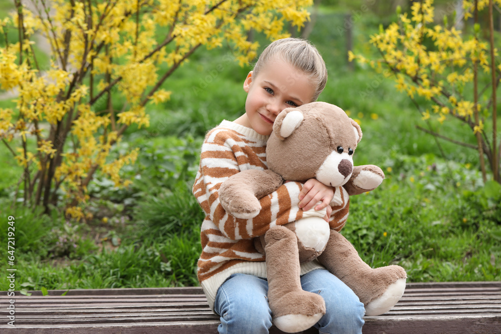 Little girl with teddy bear on wooden bench outdoors Little girl with teddy bear on wooden bench outdoors