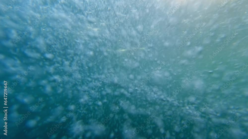 Slow motion of air bubbles ascending from the ocean floor to the water's surface, making it an excellent choice for an abstract natural background. Slow motion of air bubbles ascending from the ocean floor to the water's surface, making it an excellent choice for an abstract natural background.