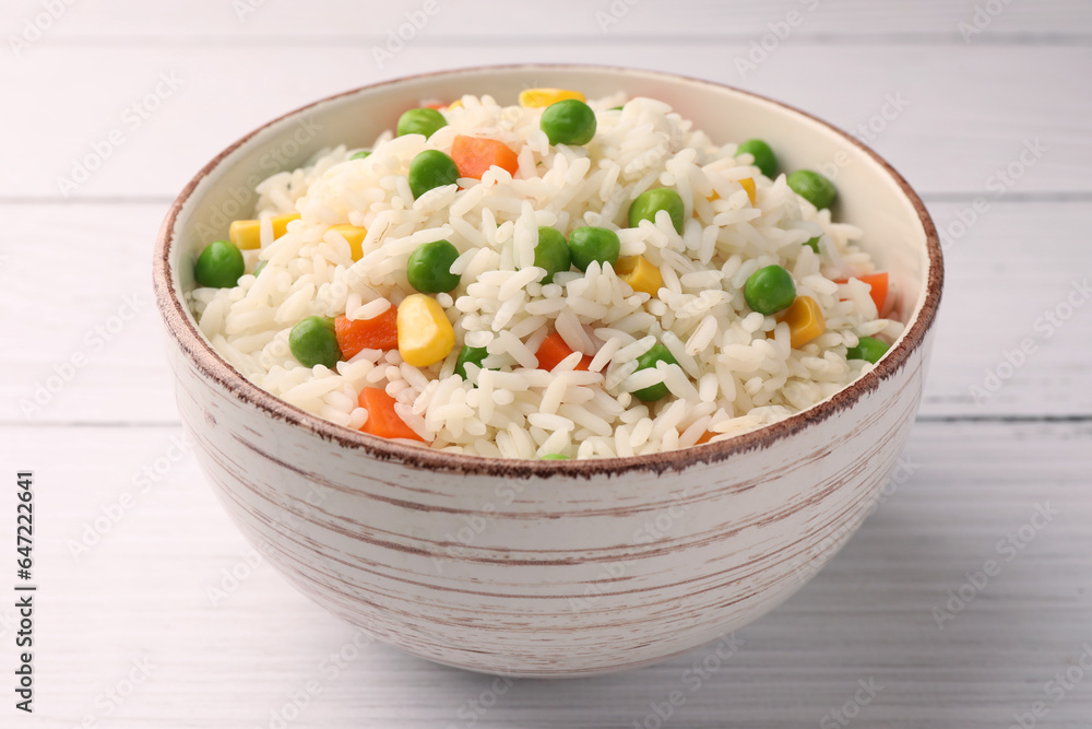 Bowl of delicious rice with vegetables on white wooden table, closeup Bowl of delicious rice with vegetables on white wooden table, closeup