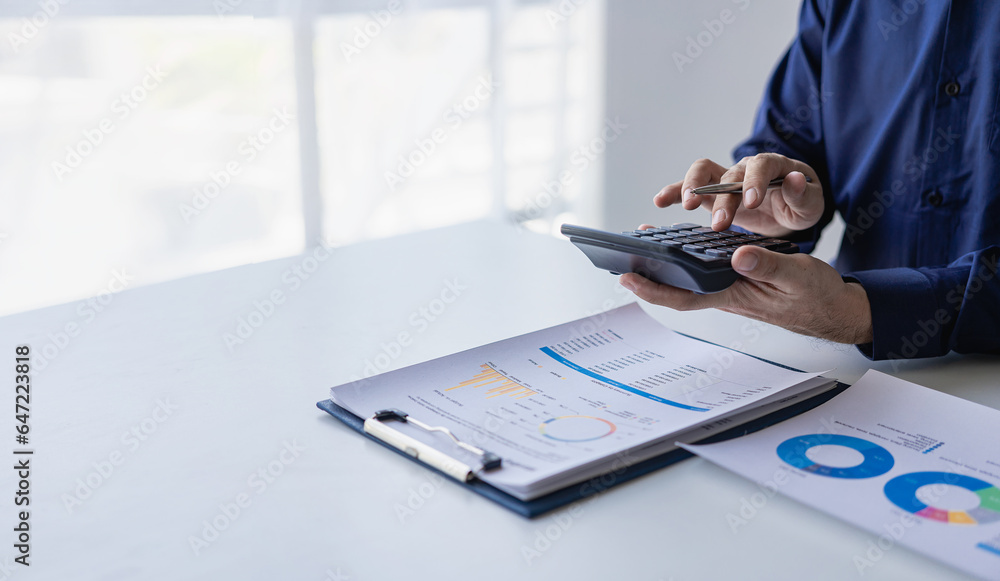 Fototapeta premium Accountant analyzes invoice investment chart and presses calculator button over document Accounting clerk, bank consultant and auditor in office close-up photo