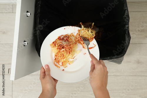 Εκτύπωση καμβά Woman throwing pasta into bin indoors, top view