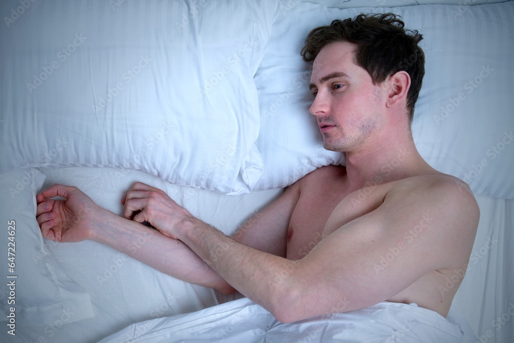 Sad man lay in bed in bedroom alone. Insomnia concept Sad man lay in bed in bedroom alone. Insomnia concept