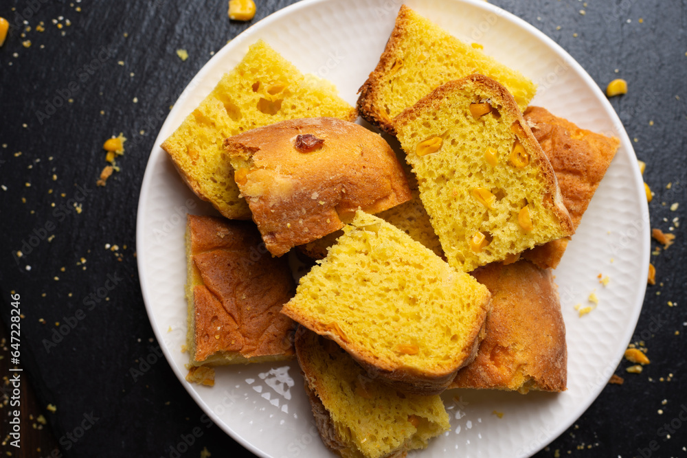 Homemade cornbread slices on white dish flat lay view