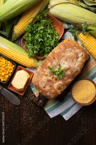 Obraz na płótnie Cut board with fresh cornbread on wooden kitchen table flat lay view w salonie