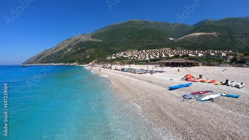 View of beach in Palasa or Palase, Albania with people swimming and having fun. Tourists enjoying summer travel in Europe. Albanian destination on Ionian Sea photo