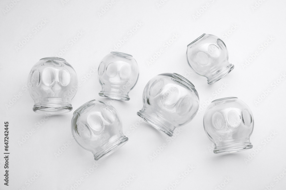 Glass cups on light grey background, flat lay. Cupping therapy Glass cups on light grey background, flat lay. Cupping therapy