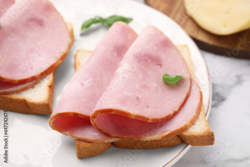 Delicious sandwiches with ham on table, closeup