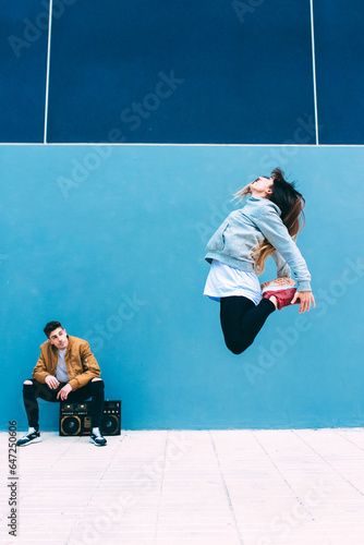 Young happy couple dancing on the street with a vintage radio cassette stereo . © DavidPrado