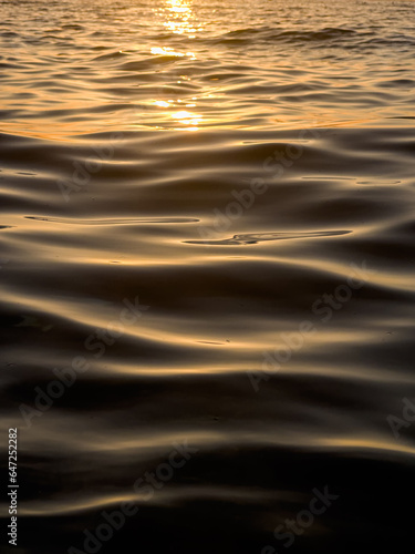 abstract waves forming on the sea at sunset ,yellow black sunset background