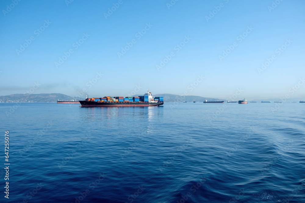 Container cargo ship loaded leaves Piraeus port Greece. Moored ship in Mediterranean sea background.