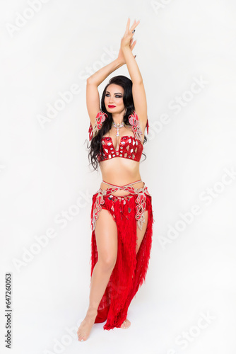 Bright beautiful brunette woman in dancing clothes on white background, studio photo shoot.