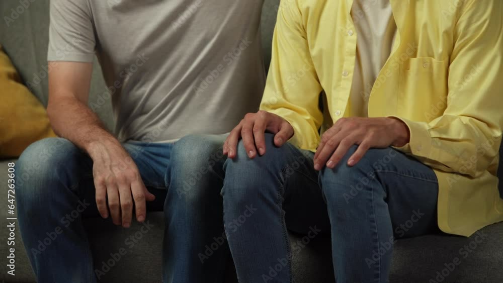 Close up video of a homosexual couple at home. The men are sitting on the couch. One tries to explain himself calmly to his partner, who seems jealous, stressed about something. Close up video of a homosexual couple at home. The men are sitting on the couch. One tries to explain himself calmly to his partner, who seems jealous, stressed about something.
