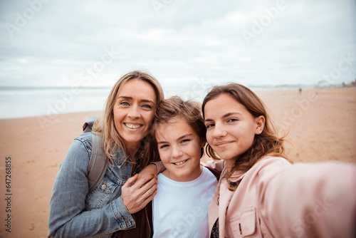 Young Caucasian family taking a selfie on the beach