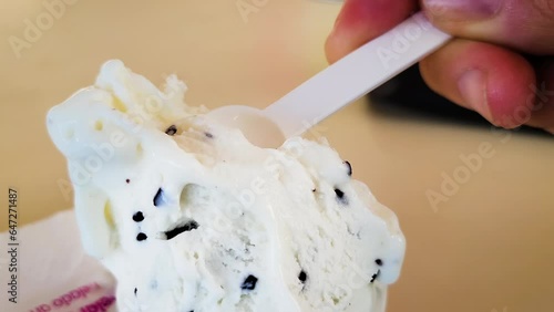 Closeup shot of a hand taking a spoonful of the soft stracciatella italina ice cream photo