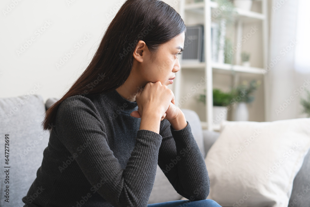 Unhappy anxiety young Asian woman covering her face with pillow on the cough in the living room at home. Unhappy anxiety young Asian woman covering her face with pillow on the cough in the living room at home.